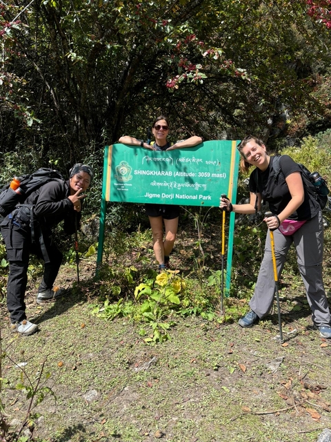 Three people posing next to a national park sign.