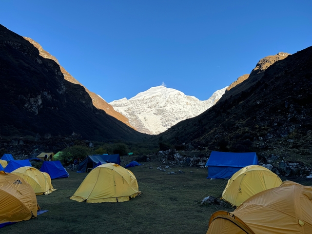 Camping site with tents and a snow-capped mountain view.