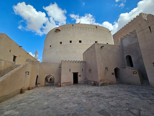 Interior of Nizwa Fort with stone walls and blue sky.