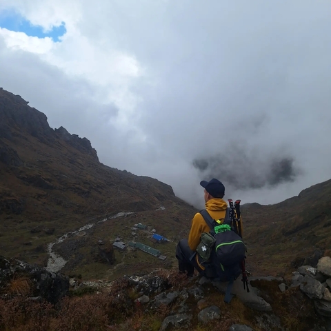       Person overlooking a valley with clouds.
  