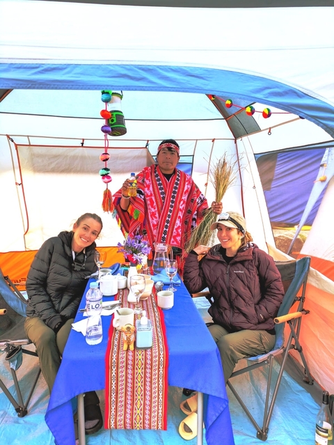       Three people dining inside a tent.
  