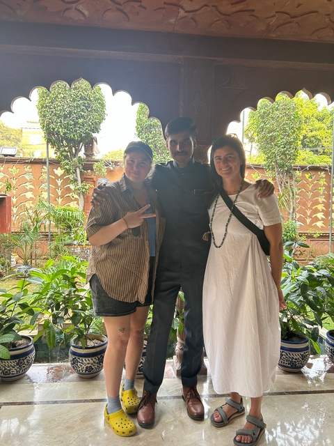 Three people posing in a garden setting.