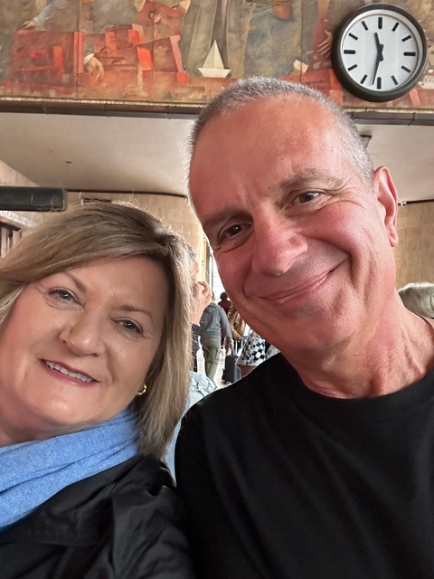 Close-up of two people smiling indoors.