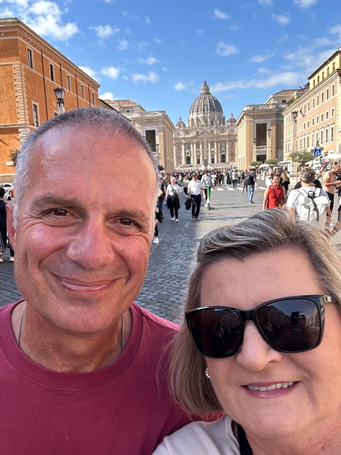 Two people posing with St. Peter's Basilica in the background.