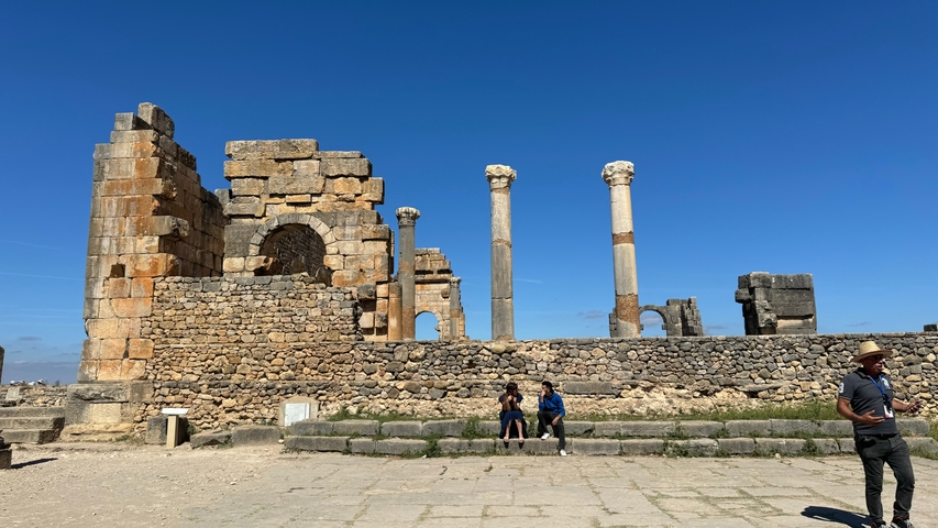       Ancient Roman ruins with a blue sky.
  
