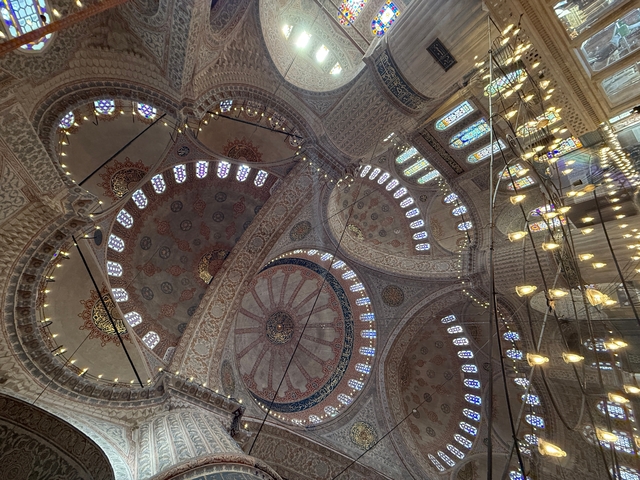       An ornate domed ceiling inside a mosque.
  