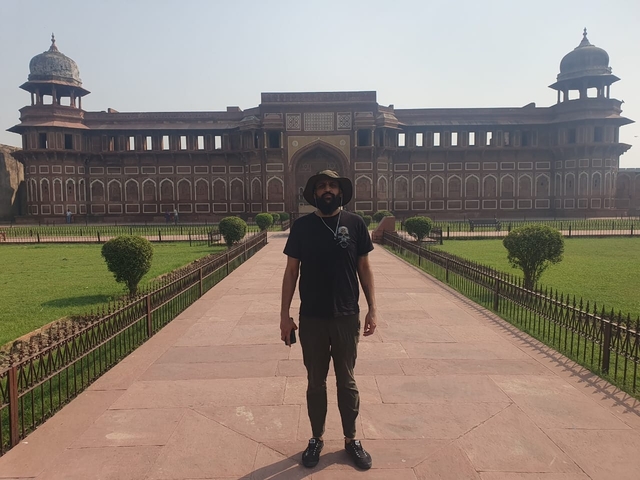 Man posing in front of a historic fort.