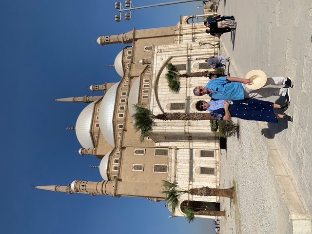       Two people posing in front of a monumental building.
  