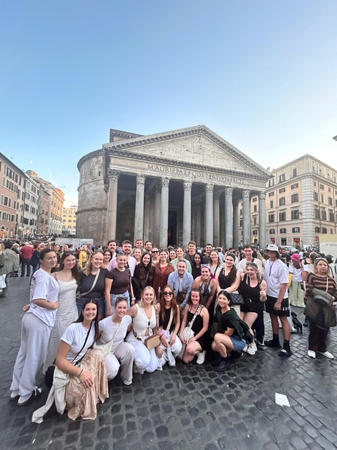 Large group of people posing in front of the Pantheon in Rome.