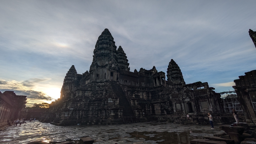       Angkor Wat temple complex with a dramatic sky at sunrise.
  