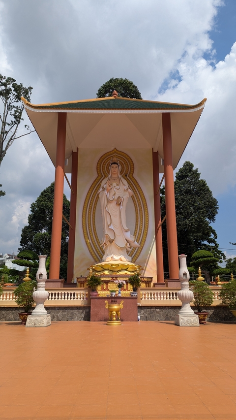       Large statue of a deity in an ornate temple courtyard.
  