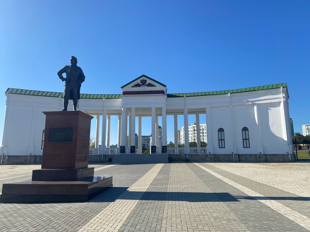       Statue in front of a building with columns.
  