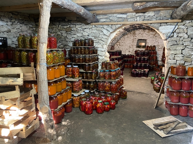       Cellar with jars of preserved fruits and vegetables.
  