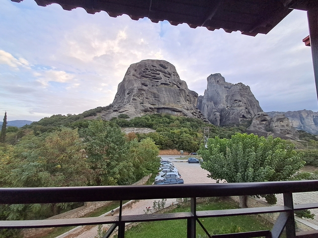       Rocky landscape with parked cars and trees.
  