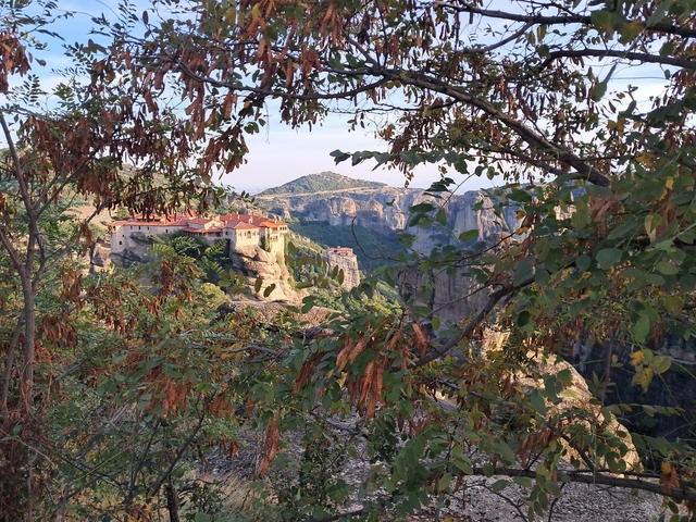       View of a monastery surrounded by greenery.
  
