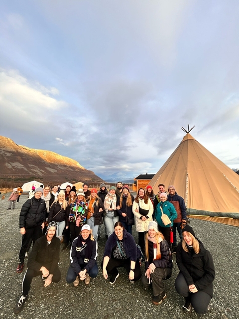       Group photo in front of a large tent in mountainous area.
  
