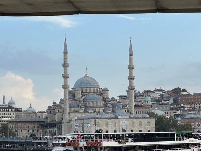       Large mosque with domes and minarets at dusk.
  