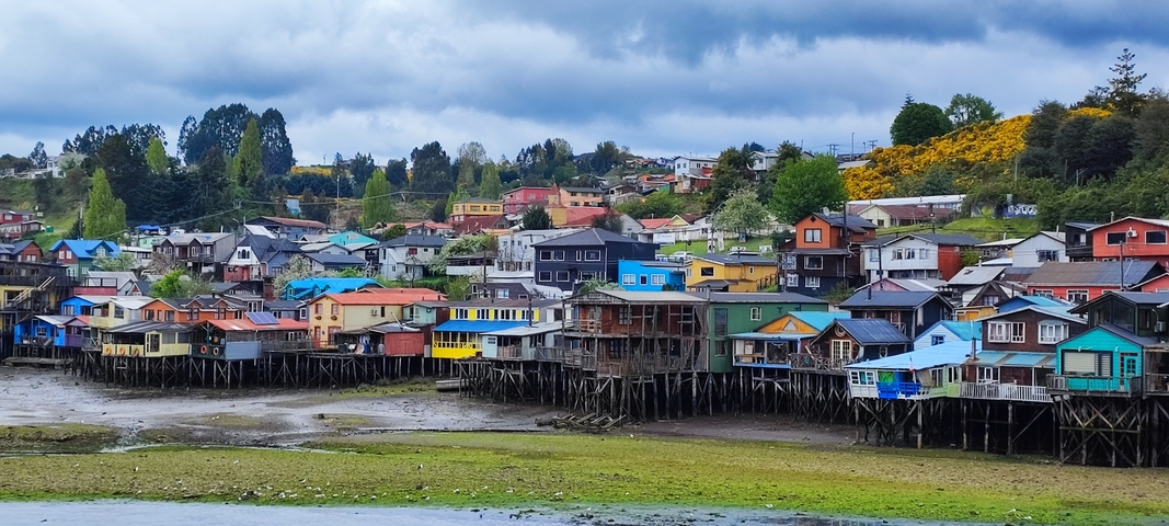       Colorful stilt houses by the water.
  