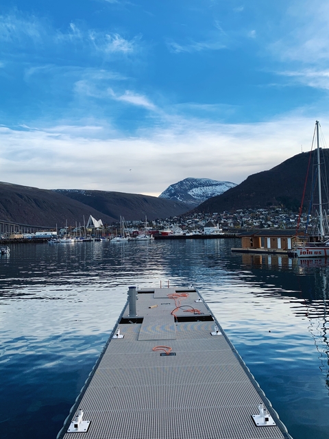       Harbor with boats and snowy mountains in the background.
  