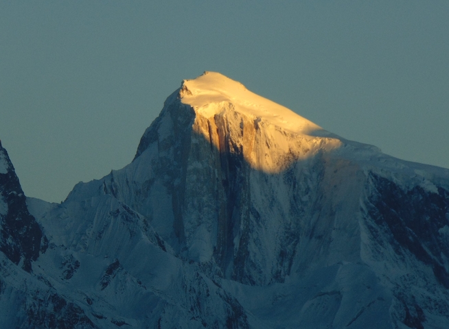 Sunset view on a mountain peak with snow.