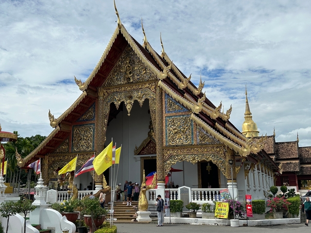       Side view of a temple with decorative elements and flags.
  
