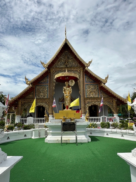       Front view of a temple with flags.
  