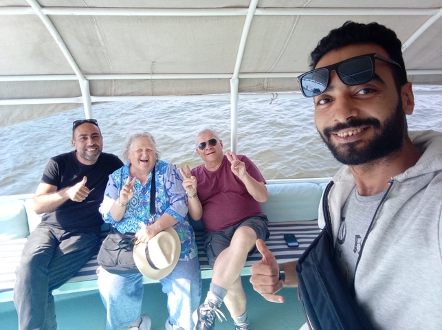       Group of people giving thumbs up on a boat.
  