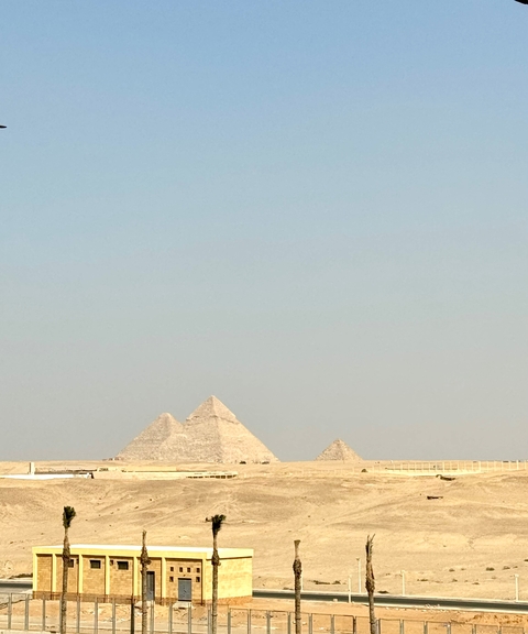       Three pyramids under a clear sky.
  