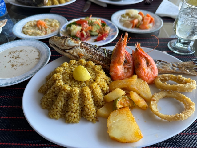       Plate of seafood with side dishes.
  