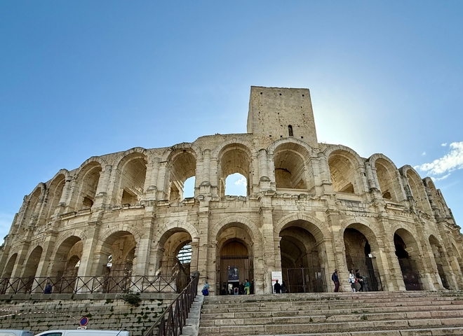       Historical stone amphitheater under a clear blue sky.
  