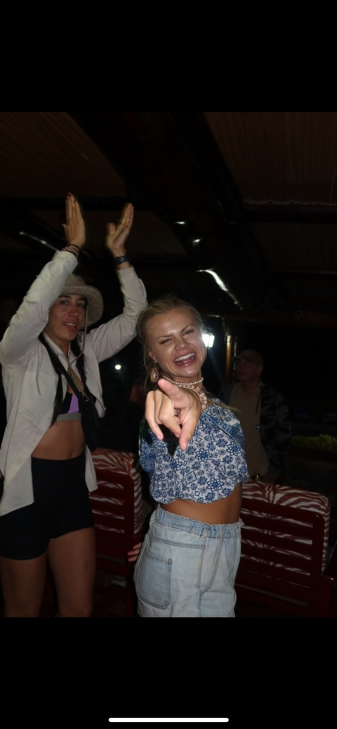       Two people dancing and having fun indoors.
  