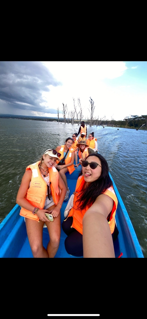       Group of people in life jackets on a boat.
  