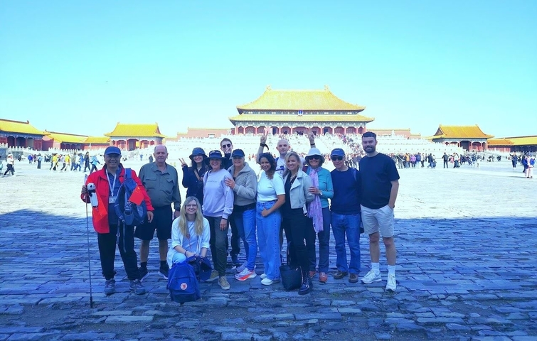 Group of tourists in front of a large traditional gate.