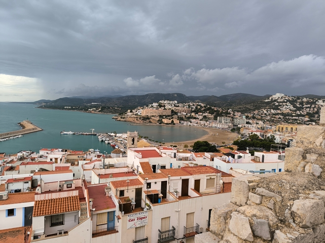 Aerial view of a coastal town with red roofs.
