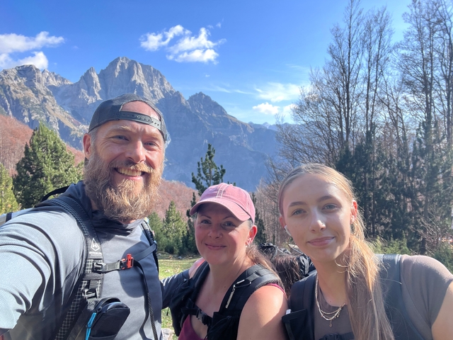 A group of people with backpacks in front of mountains.