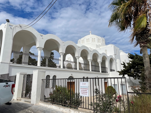 White church building with arches and blue sky.