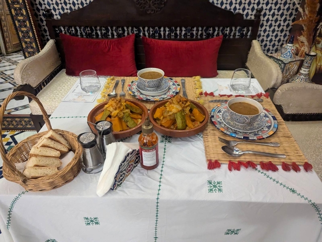       Dining table set with traditional Moroccan dishes.
  