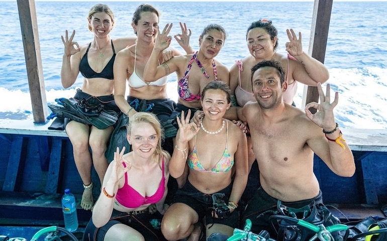       Group of smiling people on a boat.
  
