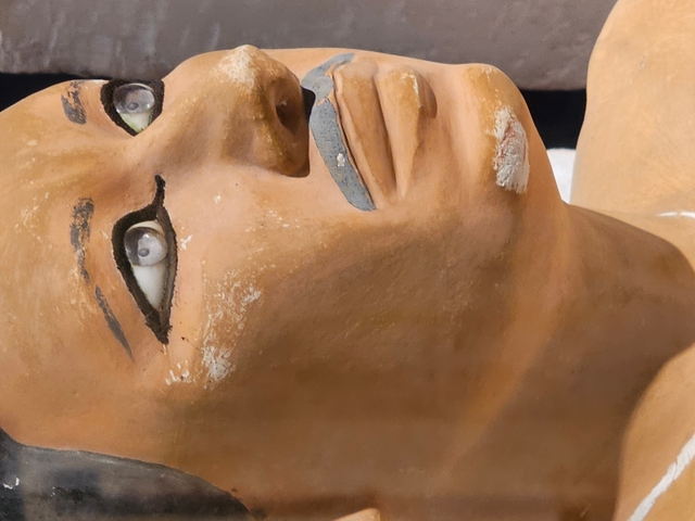       Close-up of an ancient Egyptian statue's face with detailed features.
  