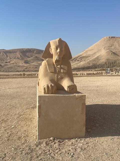 A sphinx statue in a desert setting.