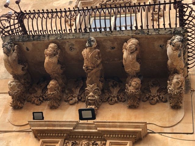       Detail of decorative balcony with intricate sculptures.
  