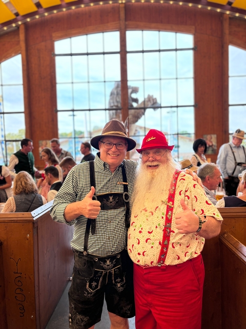 Two men in traditional outfits giving thumbs up.