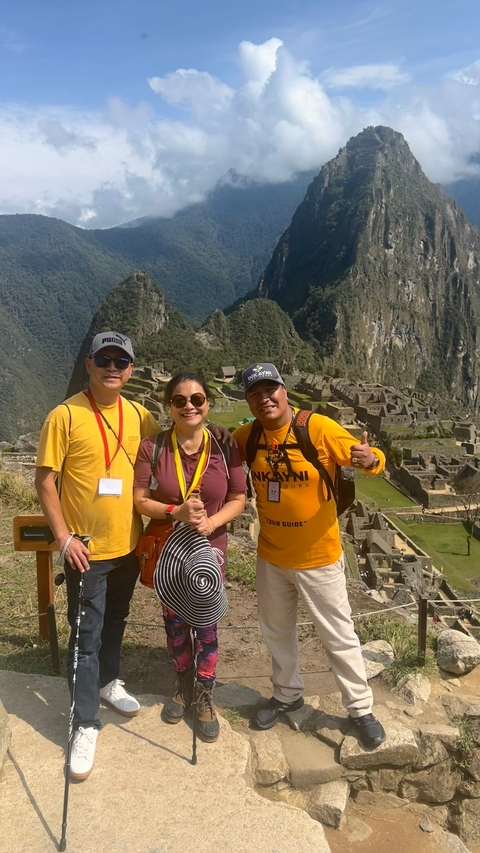       Three people posing at Machu Picchu.
  