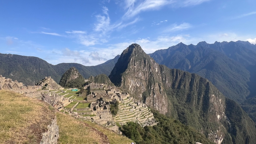       Panoramic view of Machu Picchu with surrounding mountains.
  