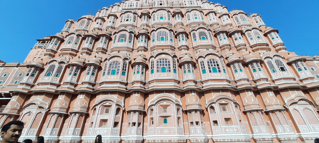       The facade of an ornate palace with colorful windows.
  