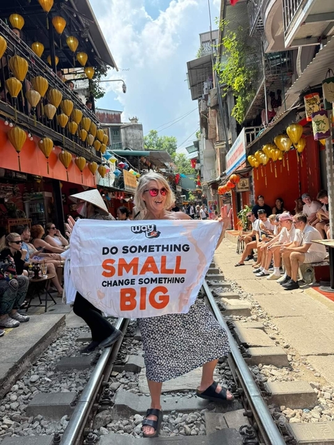 Woman holding a banner on a street with people