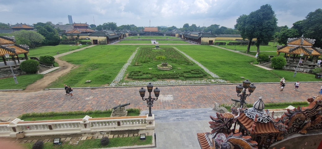 Expansive view of a historical site with green lawns and ancient structures.