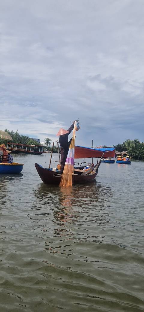       Person fishing on a boat in calm waters
  