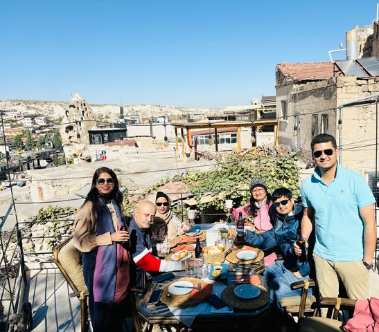       People enjoying food and drinks on a rooftop terrace.
  