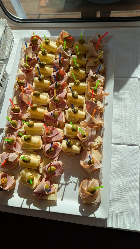       Tray of ham and cheese appetizers with olives.
  